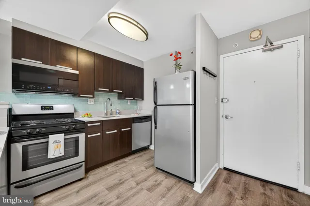 a kitchen with granite countertop a refrigerator stove and sink
