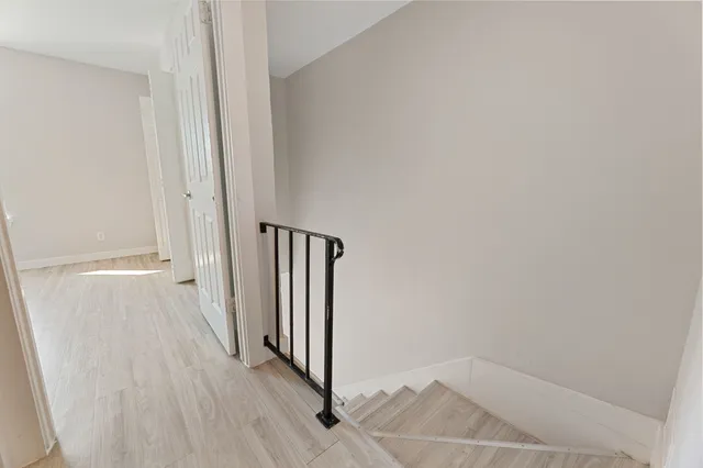an empty room with wooden floor ceiling fan and windows