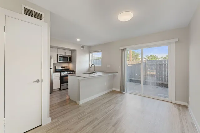a kitchen with a refrigerator and white cabinets