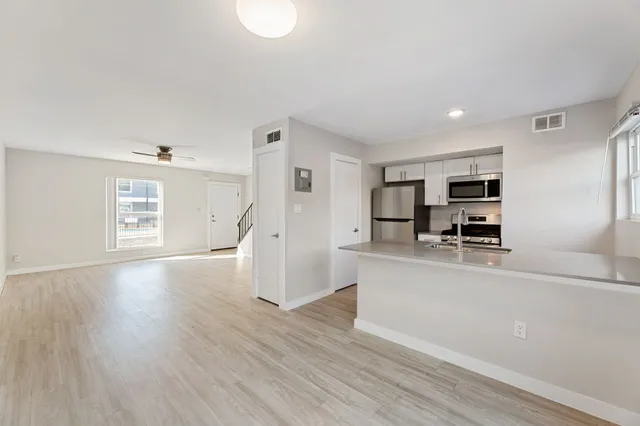 a view of a kitchen with furniture and wooden floor