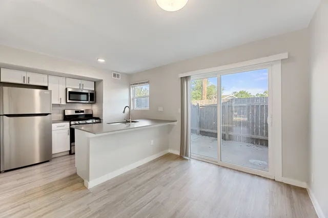 a kitchen with stainless steel appliances granite countertop a refrigerator stove top oven and sink