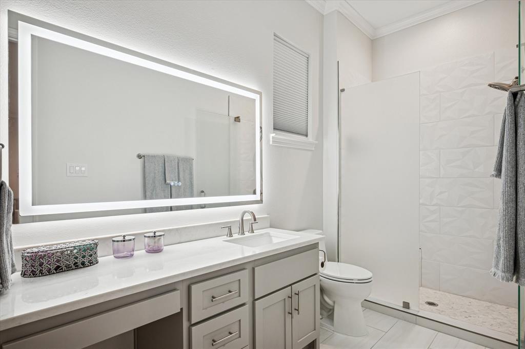 9545 Milltrail Drive Dallas, TX 75238 - Photo 15 of 30 a bathroom with a granite countertop sink a toilet and a mirror