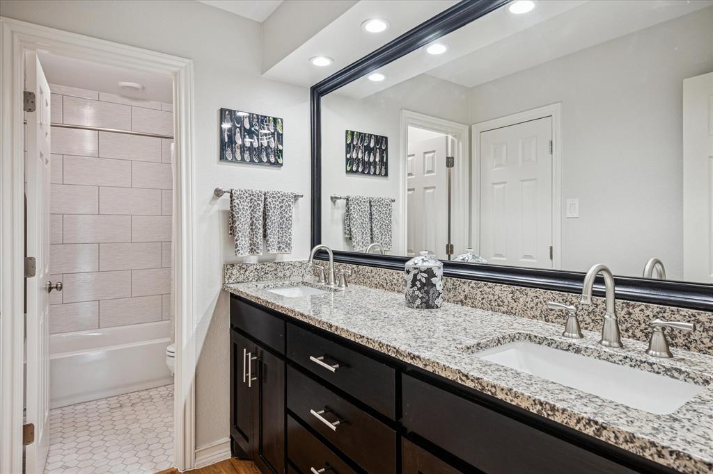 9545 Milltrail Drive Dallas, TX 75238 - Photo 16 of 30 a bathroom with a granite countertop double vanity sink and a mirror
