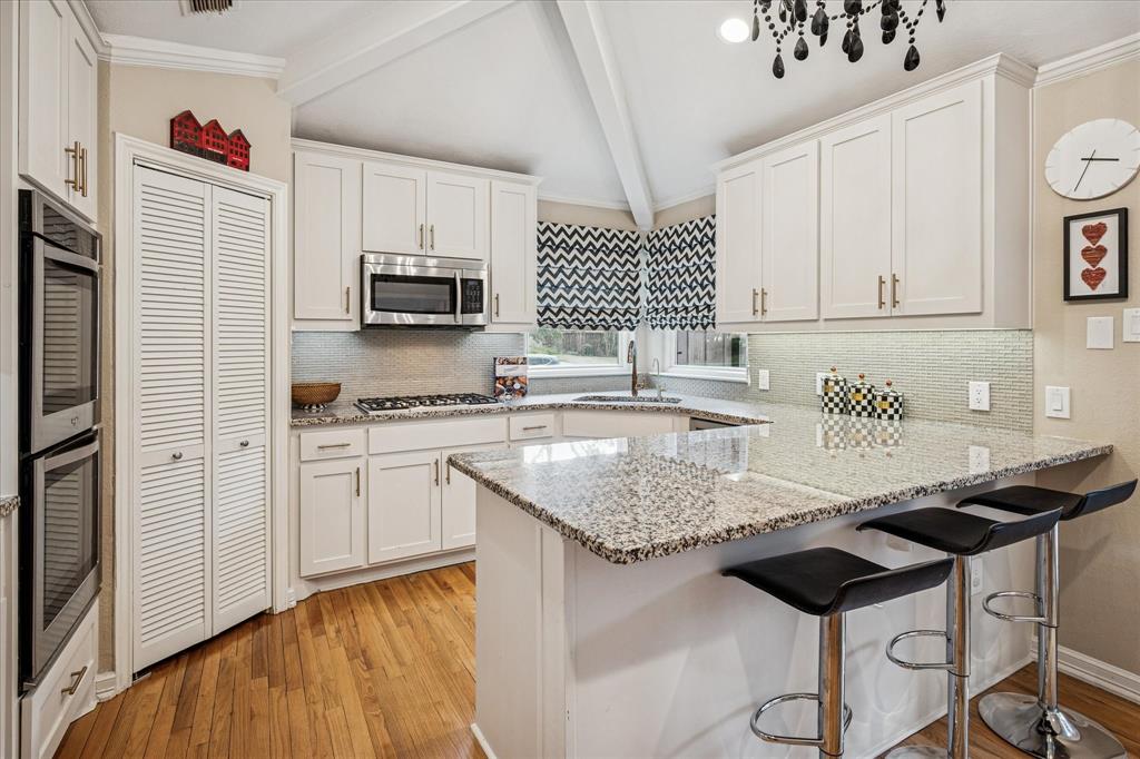 9545 Milltrail Drive Dallas, TX 75238 - Photo 2 of 30 a kitchen with granite countertop a sink cabinets and stainless steel appliances