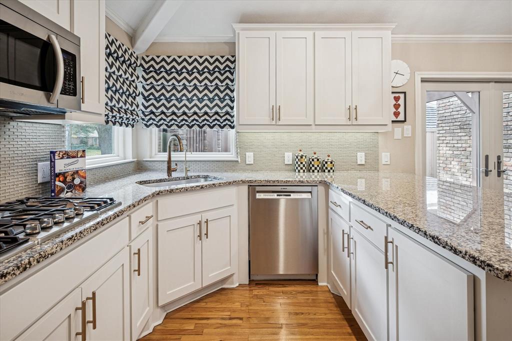 9545 Milltrail Drive Dallas, TX 75238 - Photo 3 of 30 a kitchen with granite countertop a sink stove and cabinets