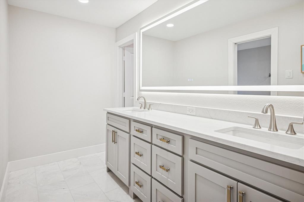 9545 Milltrail Drive Dallas, TX 75238 - Photo 9 of 30 a bathroom with a sink and a mirror