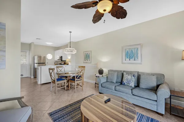 a living room with furniture kitchen view and a chandelier