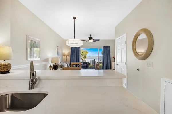 a view of living room with granite countertop a couch a chandelier a mirror and a window