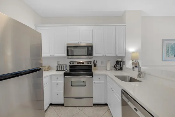 a kitchen with white cabinets sink and stainless steel appliances