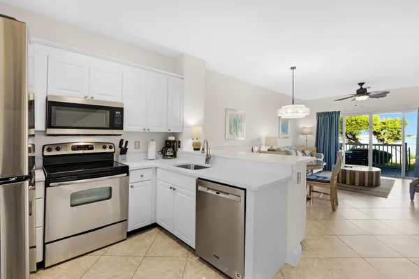 a kitchen that has a sink a stove and chairs