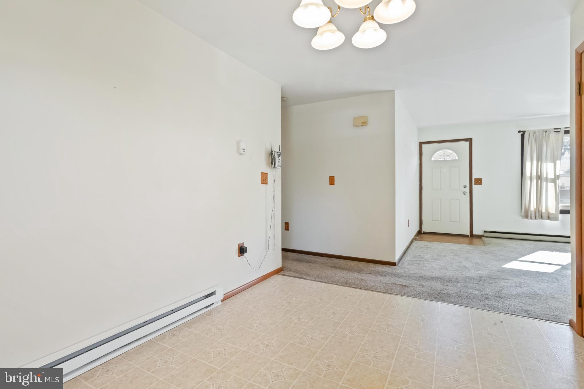 6216 Blue Grass Avenue Harrisburg, PA 17112 - Photo 8 of 23 an empty room with a chandelier fan and wooden floor