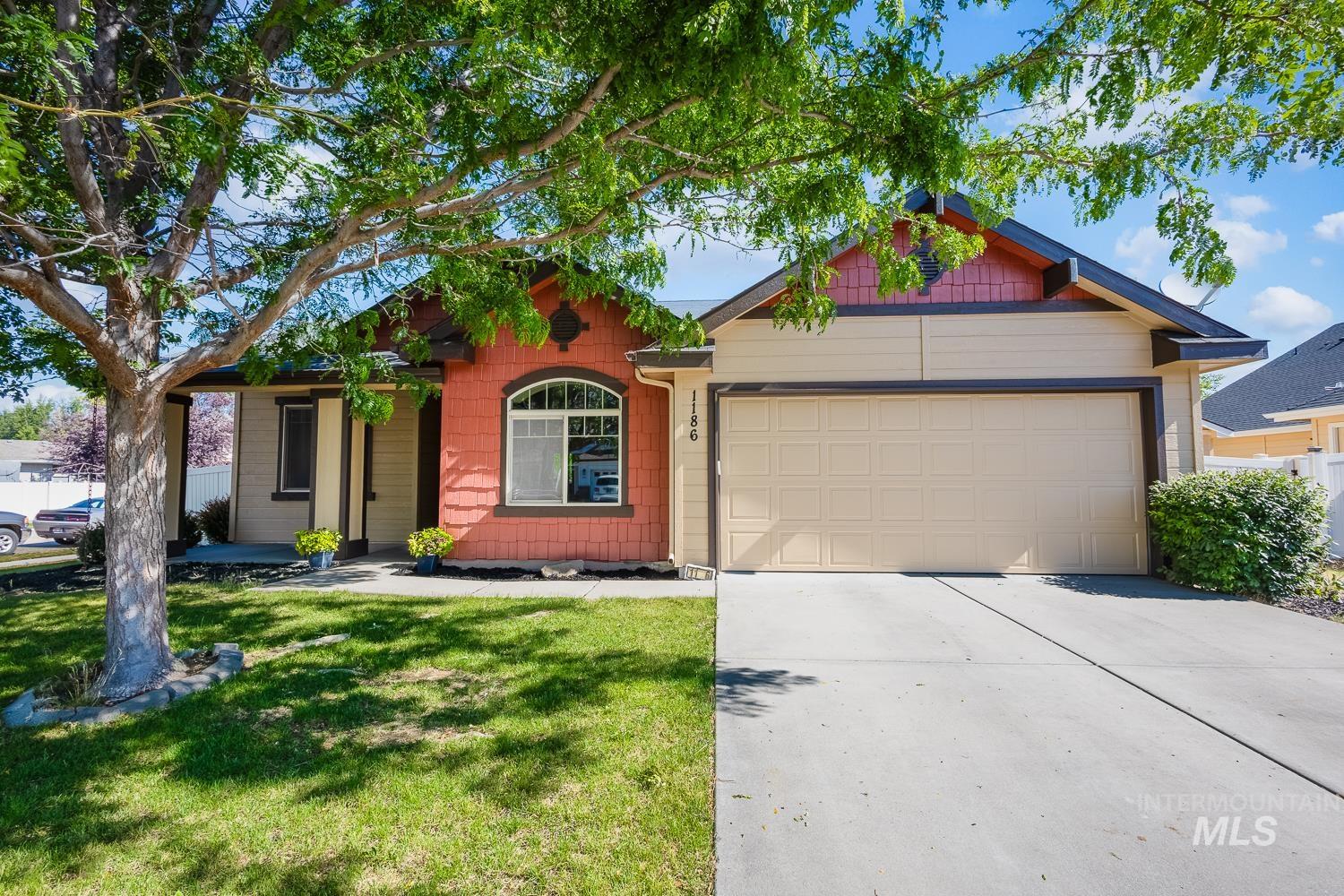 1186 East Observation Street Meridian, ID 83642 - Photo 3 of 33 Exterior featuring a two-car garage, covered porch entry, and a contrasting facade with brick-look siding and arched window