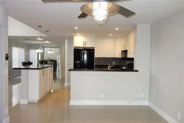 a view of a kitchen with kitchen island stainless steel appliances refrigerator stove microwave and cabinets