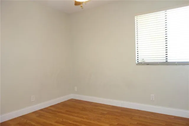an empty room with wooden floor and a window