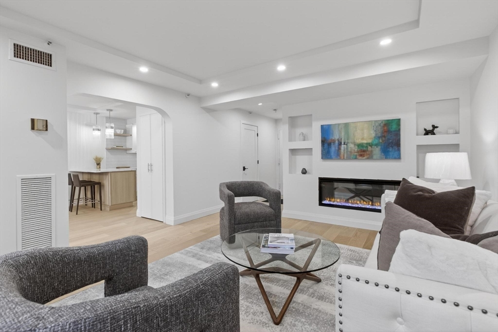 1731 Beacon Street, Unit 114 Brookline, MA 02445 - Photo 2 of 17 a living room with furniture and a fireplace