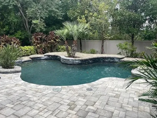 a view of a backyard with plants and a lake view