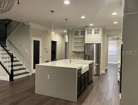 a large kitchen with stainless steel appliances a stove and a refrigerator