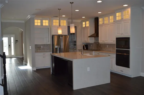 a kitchen with stainless steel appliances granite countertop a refrigerator a sink and a stove