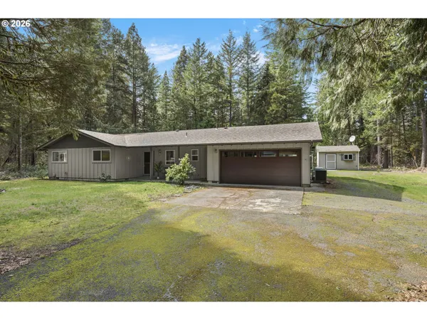 a front view of house with yard and trees in the background