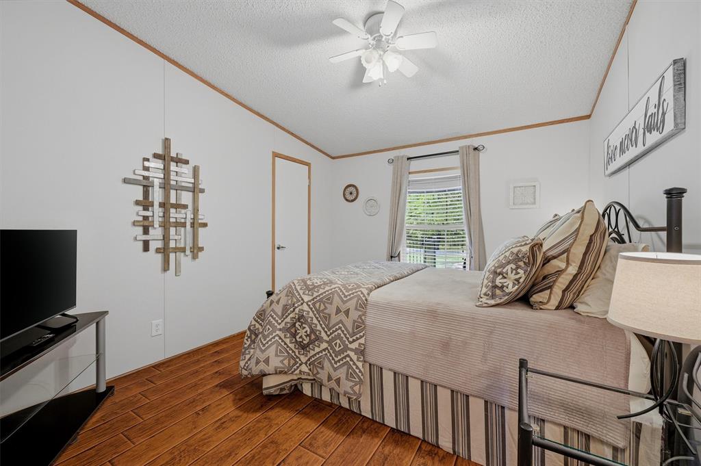 212 Sunset Road Pottsboro, TX 75076 - Photo 19 of 40 a bedroom with a bed and a flat tv screen on dresser
