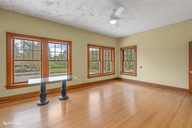 a view of an empty room with a window and wooden floor