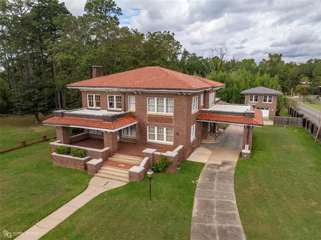 a aerial view of a house with a yard table and chairs