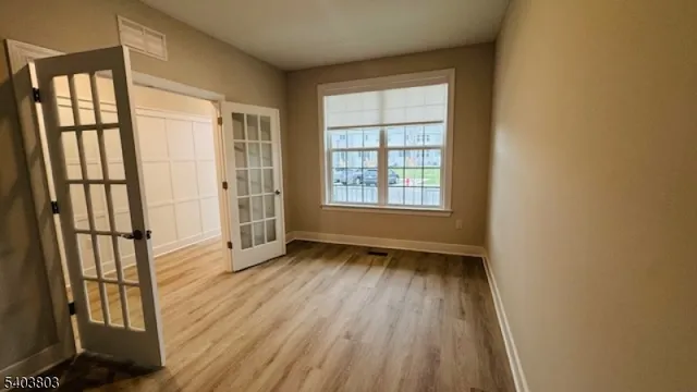 an empty room with wooden floor and windows