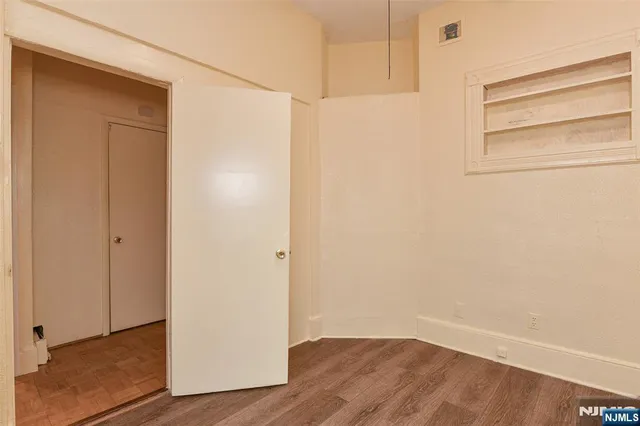 a view of an empty room with wooden floor