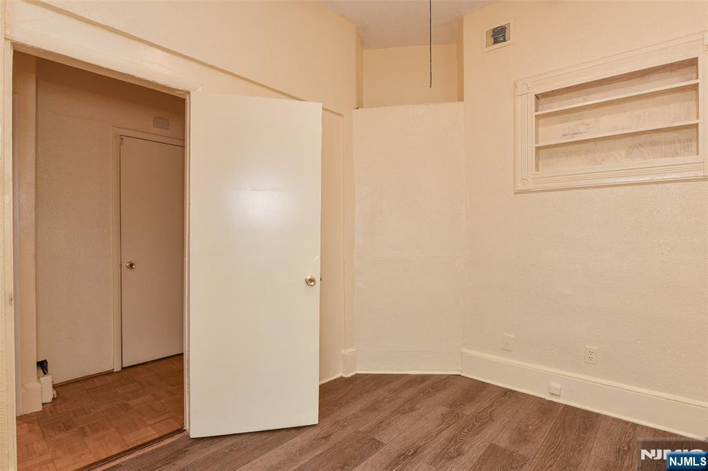 208 4th Street Passaic, NJ 07055 - Photo 11 of 28 a view of an empty room with wooden floor