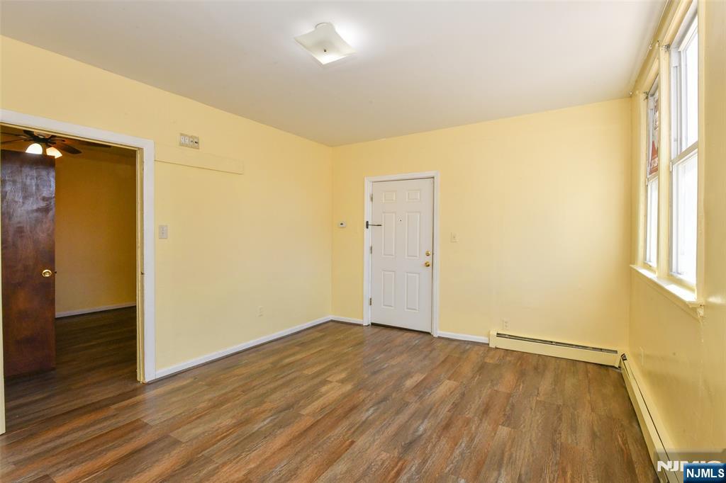 208 4th Street Passaic, NJ 07055 - Photo 14 of 28 an empty room with wooden floor and windows