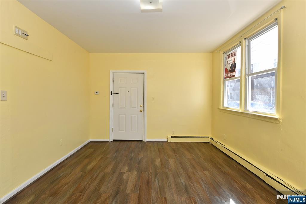 208 4th Street Passaic, NJ 07055 - Photo 17 of 28 an empty room with wooden floor and windows