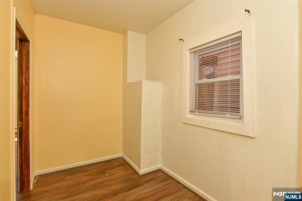 208 4th Street Passaic, NJ 07055 - Photo 19 of 28 a view of an empty room with wooden floor and a window