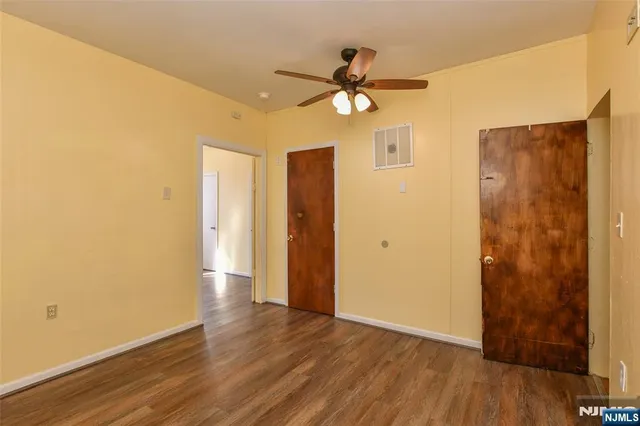 a view of a livingroom with wooden floor and a ceiling fan