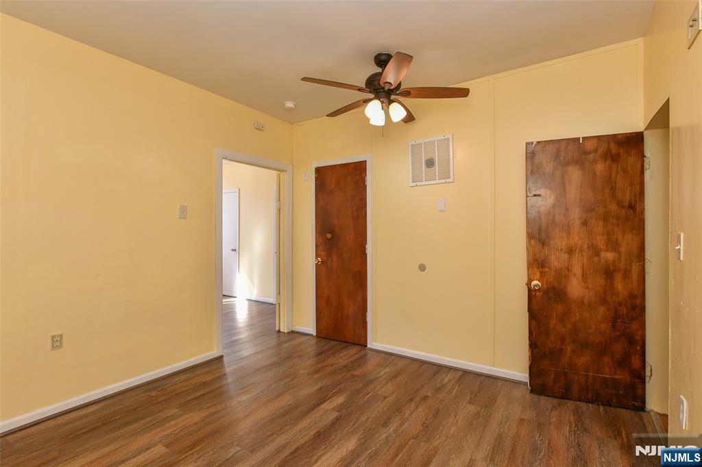 208 4th Street Passaic, NJ 07055 - Photo 21 of 28 a view of a livingroom with wooden floor and a ceiling fan