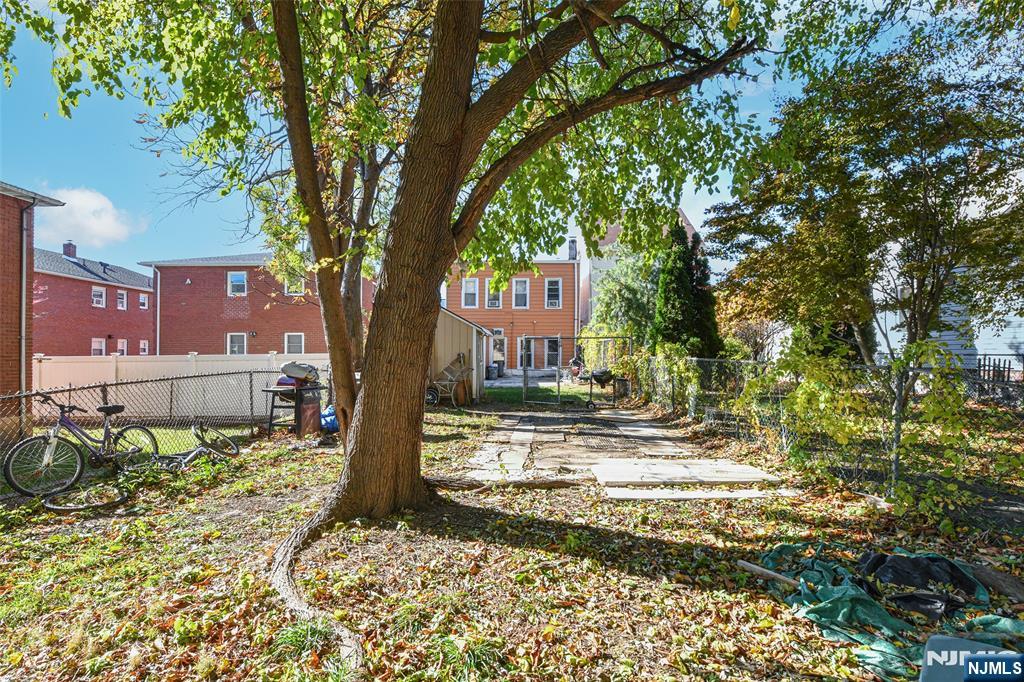 208 4th Street Passaic, NJ 07055 - Photo 24 of 28 a view of a house with a yard covered with snow and trees