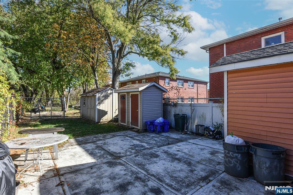 208 4th Street Passaic, NJ 07055 - Photo 25 of 28 a view of backyard with large tree and wooden fence