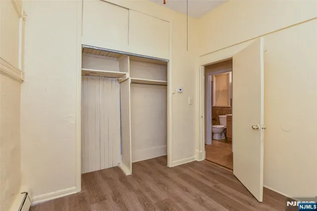 a view of an empty room with closet and a window