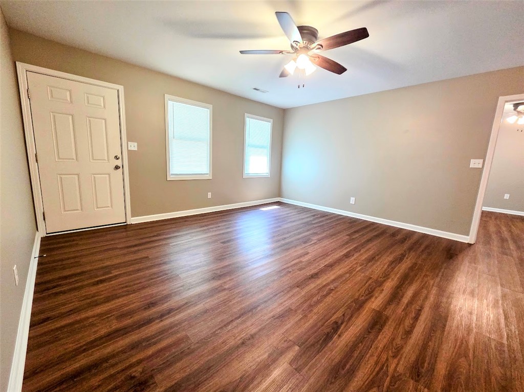 509 Elrod Road Piedmont, SC 29673 - Photo 3 of 28 Rich hardwood-style flooring extends through this airy living space, illuminated by natural light and overhead fan.