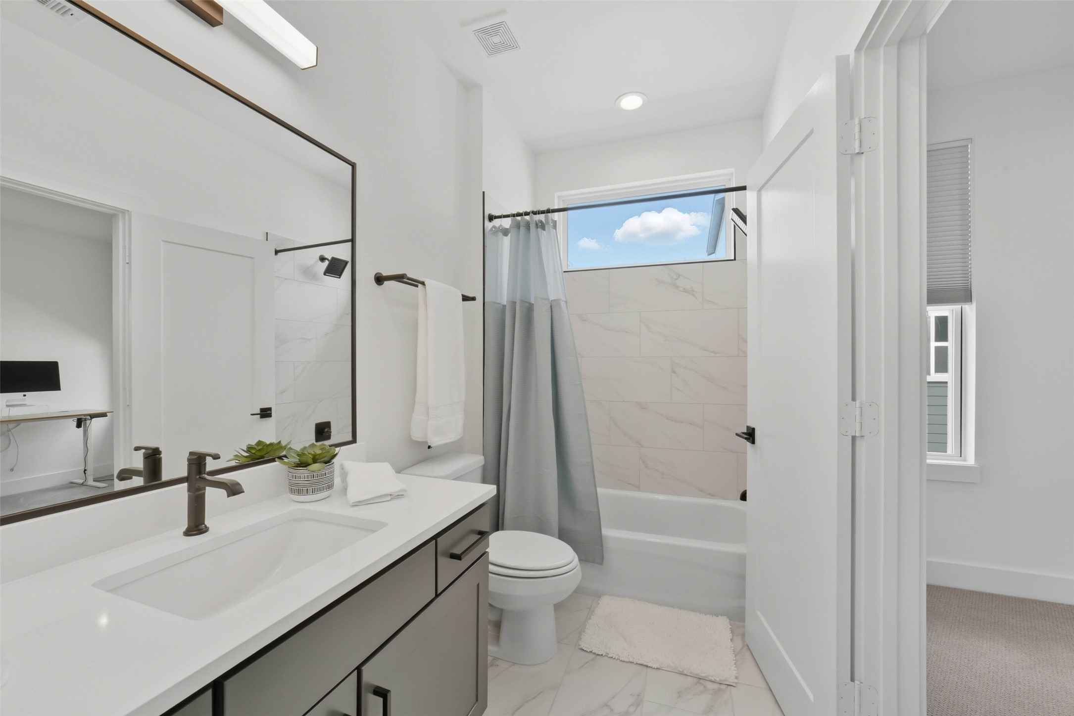3006 Lamar Street Houston, TX 77003 - Photo 32 of 46 a bathroom with a granite countertop sink toilet a large mirror a shower and a bathtub