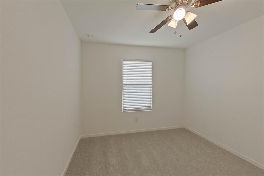834 Ginkgo Way Princeton, TX 75407 - Photo 6 of 27 an empty room with a chandelier fan and windows