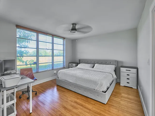 a bedroom with a bed and a large window
