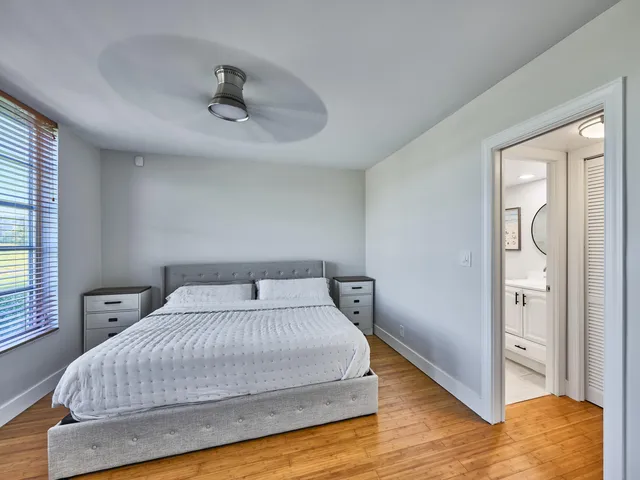 a bedroom with a bed and wooden floor
