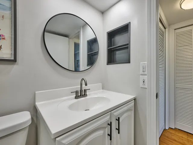 a bathroom with a sink a toilet and a mirror