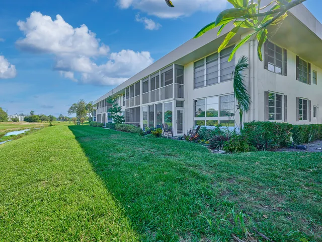 a view of a big building with big yard and large trees