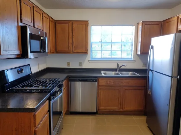 a kitchen with stainless steel appliances granite countertop a refrigerator sink and cabinets