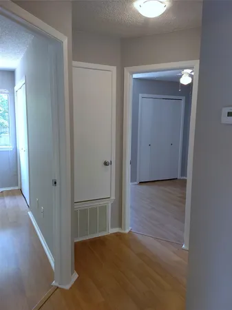 a view of a hallway with wooden floor