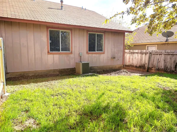 a view of backyard with a barn and a large tree