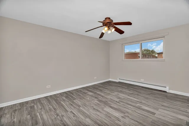 a view of room with wooden floor ceiling fan and window