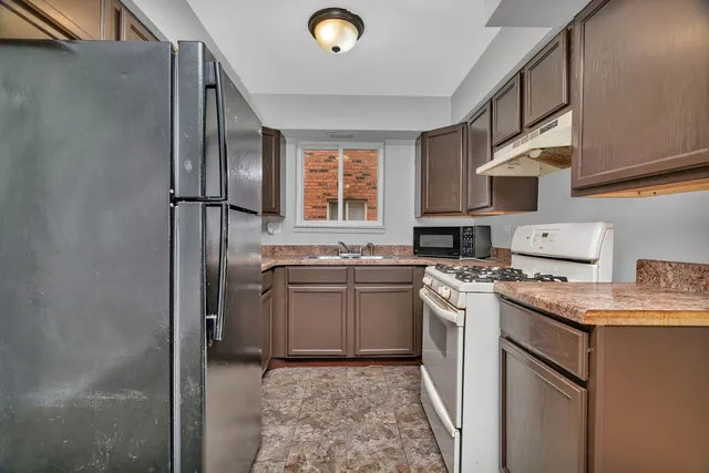 a kitchen with stainless steel appliances granite countertop a sink stove and refrigerator