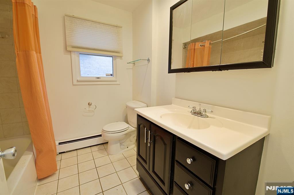 1160 River Road, Unit 1 Edgewater, NJ 07020 - Photo 12 of 18 a bathroom with a sink toilet and mirror